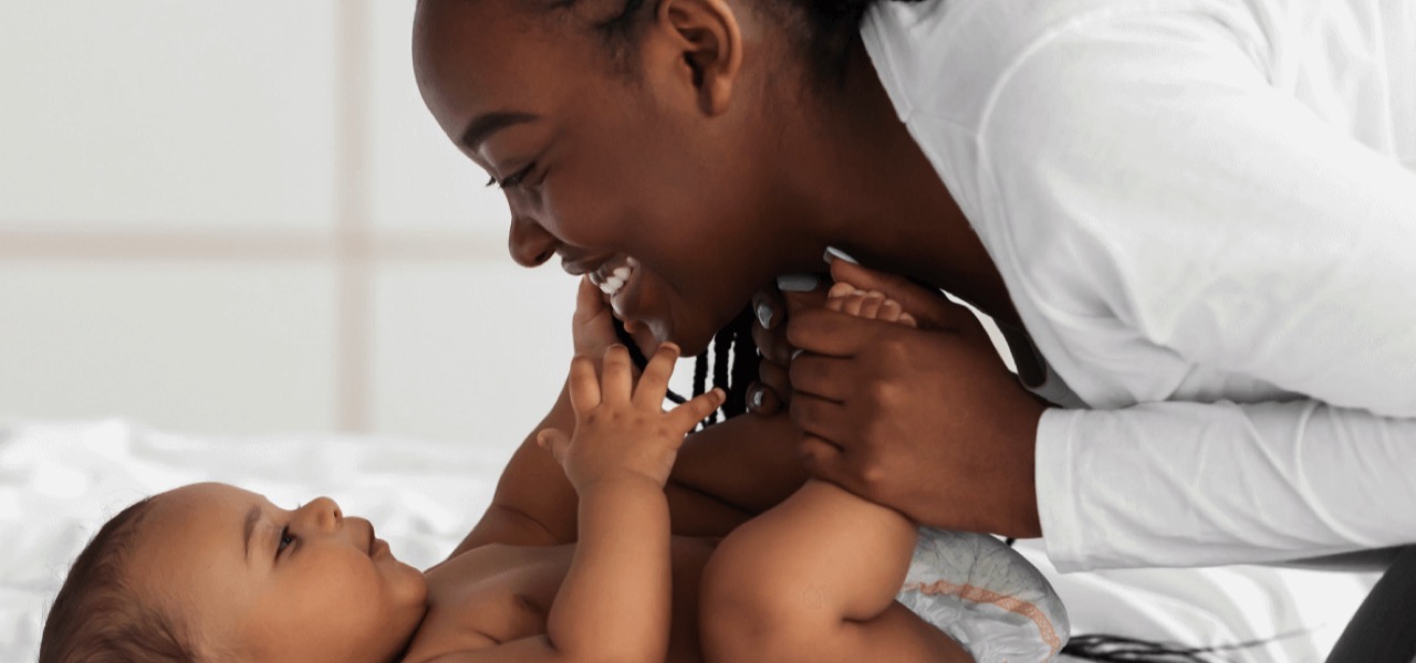 Woman holding a baby's feet while smiling lovingly